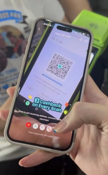 A person holds an iPhone displaying a QR code scanner app showing R$35.00 for a payment via PIX, with a "Cashback on Every Scan" banner visible. This illustrates the post's point about using Arq Finance in Brazil, where users can fund with USDC or USDT and pay via PIX at favorable rates.