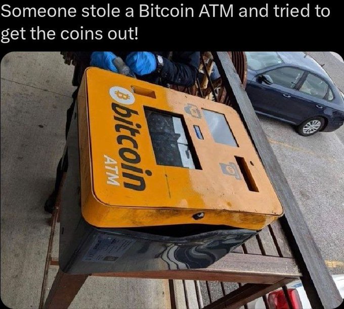 A stolen Bitcoin ATM sits on a metal grate, with the caption 'Someone stole a Bitcoin ATM and tried to get the coins out!' highlighting the apparent failed attempt, showing the yellow machine with 'bitcoin ATM' branding.