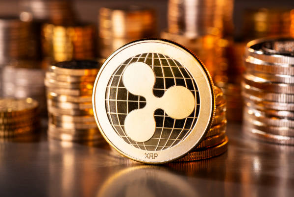 A close-up of stacked gold-colored XRP cryptocurrency coins.