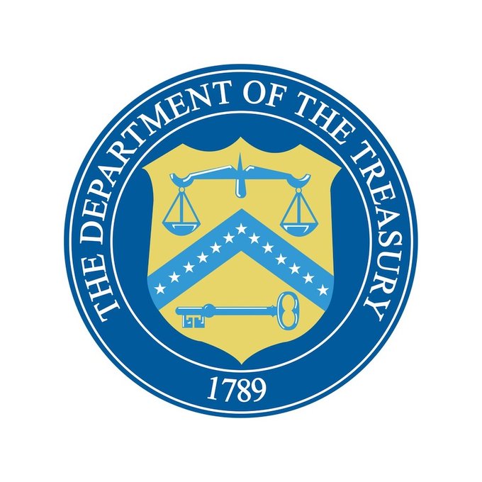 The image displays the official seal of the U.S. Department of the Treasury, featuring a blue circular border with "THE DEPARTMENT OF THE TREASURY" inscribed around it, a central shield with scales of justice, a chevron of stars, and a key, along with the founding year "1789" at the bottom. The seal relates to the post as it represents the federal agency responsible for the ongoing 60-day public comment period on GENIUS Act stablecoin regulations, following the missed July finalization deadline.