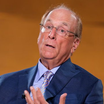 Larry Fink, CEO of BlackRock, is shown speaking at an event while wearing a blue suit and tie, gesturing with his hands. The image relates to the post as it depicts the leader of BlackRock, the asset management firm whose clients reportedly sold $23.8 million worth of Ethereum ($ETH).