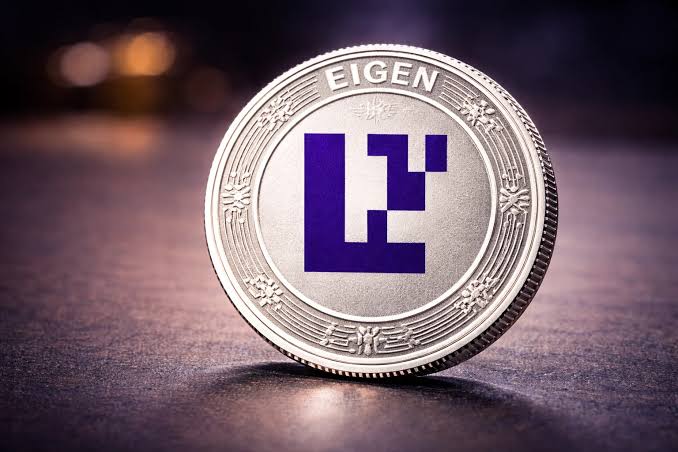 A silver coin labeled 'EIGEN' with a purple 'L' symbol displayed on a dark surface.