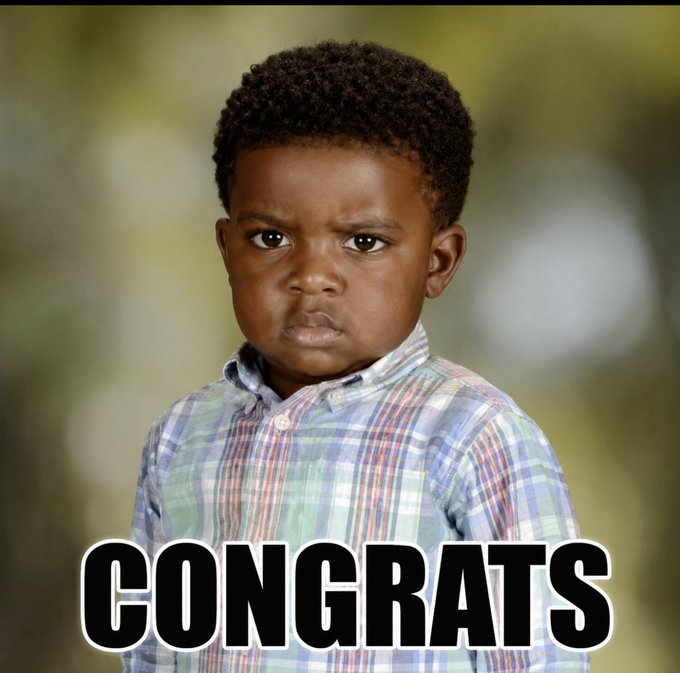 A young boy with a skeptical, unimpressed expression wearing a plaid shirt, with the word 'CONGRATS' displayed in large white text at the bottom.