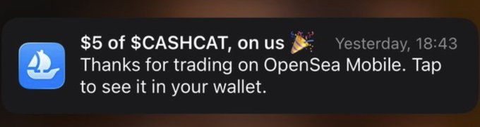 A mobile notification from OpenSea reads: "$5 of $CASHCAT, on us 🎉 Thanks for trading on OpenSea Mobile. Tap to see it in your wallet," timestamped Yesterday, 18:43. The notification corresponds to the post's mention of OpenSea's $5 airdrop reward for users who trade via the mobile app.