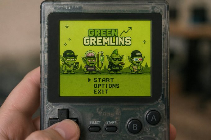 A hand holds a transparent Game Boy-style handheld console displaying the title screen for a game called 'GREEN GREMLINS' featuring four pixel-art goblin characters labeled DeFi, NoFap, HODL, and NFT, with menu options to Start, Options, or Exit.