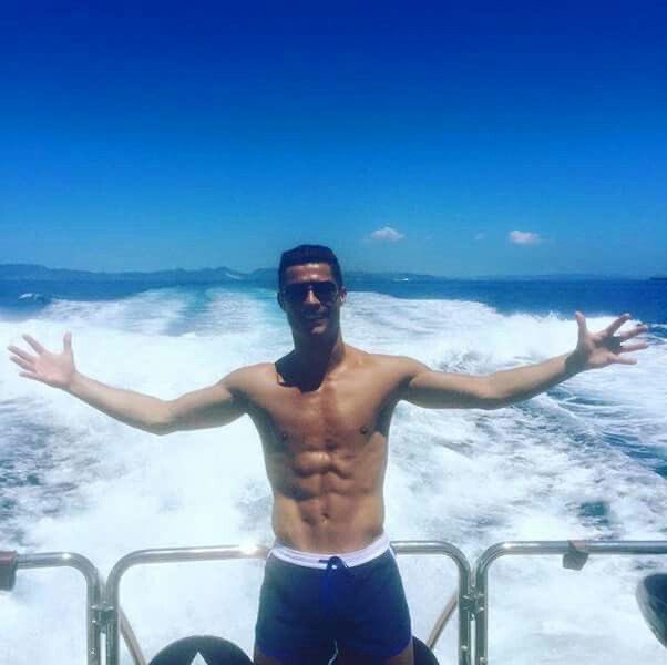 A fit, shirtless man with sunglasses stands on the back of a speeding boat, arms triumphantly outstretched, riding the ocean waves under a clear blue sky. The triumphant, celebratory pose mirrors the post's excitement about a "generational run" in stocks, capturing the same victorious, carefree energy of a massive financial win.