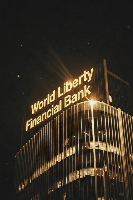 The image features a tall building at night, illuminated by bright lights that make it stand out against the dark sky. The building has a sign for World Liberty Financial Bank, which reads "World Liberty Financial Bank" above its glass windows. The scene suggests that the bank is actively growing and expanding in the city, as indicated by the glowing lights on top of the building.