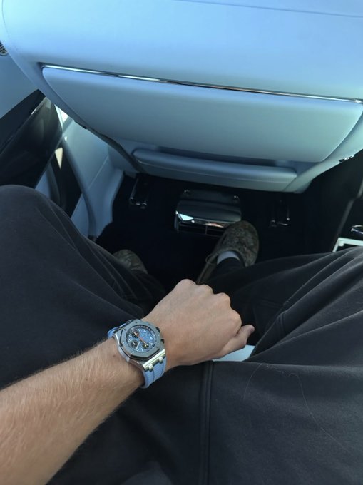 A man wearing a silver chronograph watch sits in the luxury interior of a car, legs crossed. The watch photo complements the post's flex about hitting $1.2 on SOL, showcasing a similar "flexing" lifestyle moment typical of crypto traders celebrating gains.