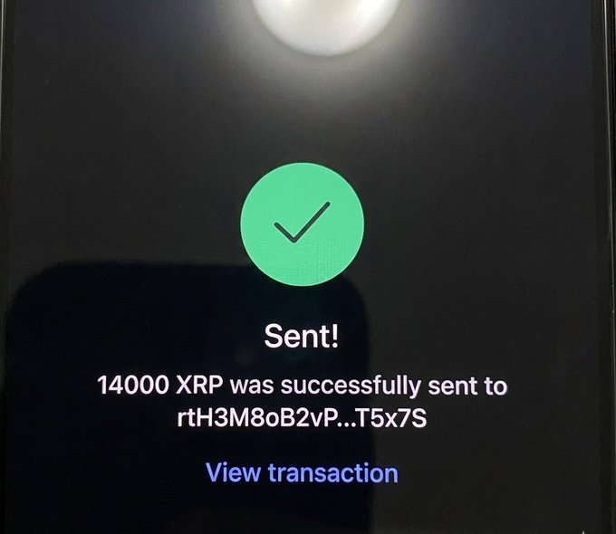 The image shows a black cell phone screen displaying an email message with a green checkmark symbolizing successful transmission of an $14,000 payment to another person who has never won a raffle before. The text indicates that the payment was sent successfully via Bitcoin.
