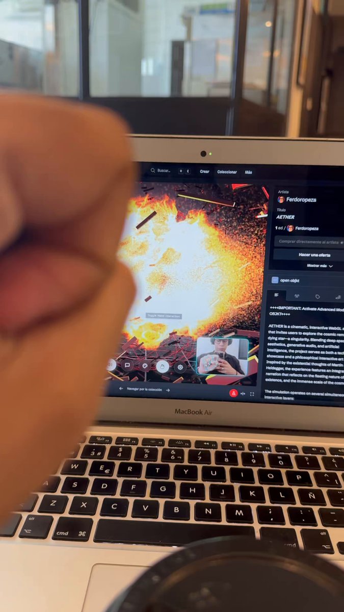 urn of fire and explosions on a laptop screen, accompanied by a thumbs-up gesture from the user's hand.