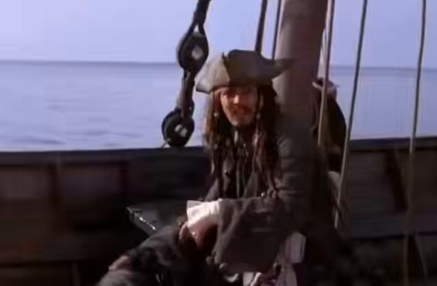 The image shows a pirate ship with a man wearing a tall hat sitting in one of the portholes, looking towards the camera. The background features a vast body of water, which adds an adventurous atmosphere to the scene. The caption associated with this image is "Me checking in on my friends who fomo bought XRP at $3.23 in 2025.", which implies that someone has purchased Ripple cryptocurrency and is now sharing their success story or promoting it.
