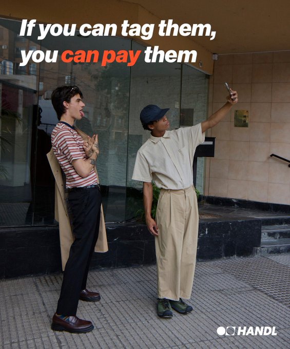 Two young people take a selfie on a city sidewalk beneath bold text reading "If you can tag them, you can pay them," with the "HANDL" logo displayed in the corner—visually reinforcing the post's message about getting paid for being tagged online.