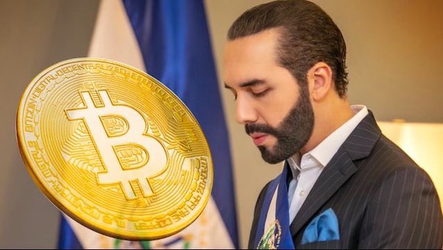 A man in a dark suit stands with eyes closed next to a large golden Bitcoin coin, with text reading 'BTC'.