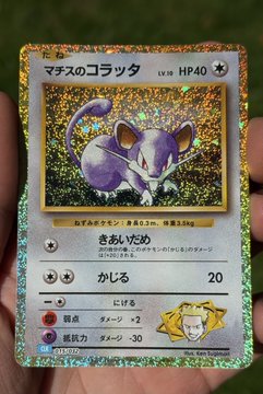 A holographic Japanese Pokémon trading card featuring Rattata ('マタスのコラッタ') at LV8 with HP40, held in a person's hand.