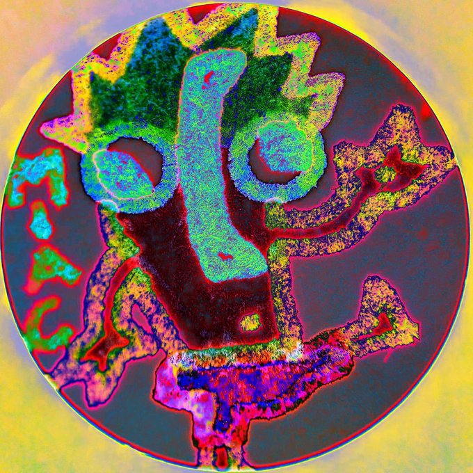A vibrant, psychedelic illustration shows a stylized figure with a crown-like headpiece rendered in iridescent neon colors of green, blue, pink, and yellow within a circular frame.