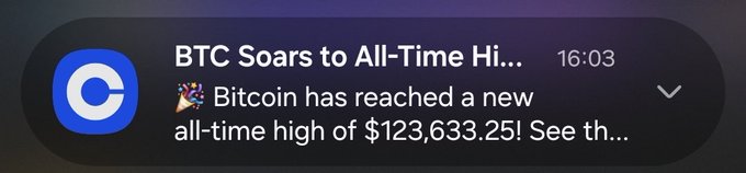 A smartphone notification from Coinbase displays the headline 'BTC Soars to All-Time Hi...' at 16:03, with a preview stating that Bitcoin has reached a new all-time high of $123,633.25.