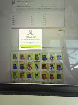 A photograph of a computer screen displaying 'THE PROTOCOL' interface with a popup showing '+9.37%' profit and a grid of collectible items below.