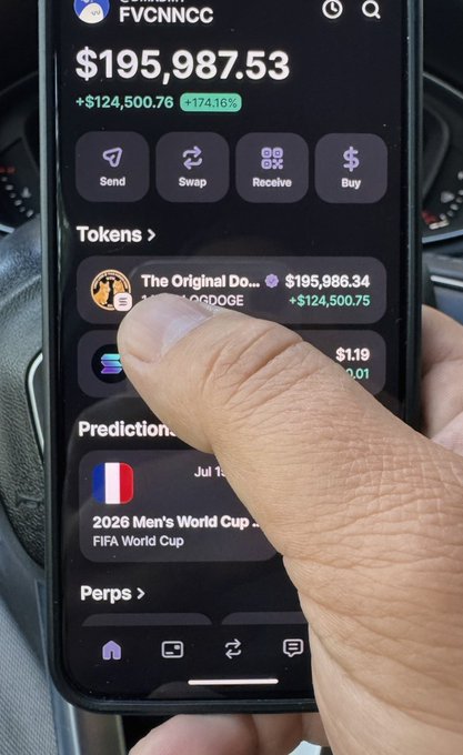 The image shows a person's hand holding a cell phone displaying various app icons and text. The main focus of the image is the person's finger pointing towards an item on their phone screen, possibly a message or a piece of information related to Bitcoin trading.