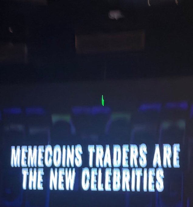 A dimly lit venue with empty seats is overlaid with bold text reading "MEMECOINS TRADERS ARE THE NEW CELEBRITIES," humorously tying into the post's "gm otta" greeting by suggesting memecoin traders have risen to celebrity status.