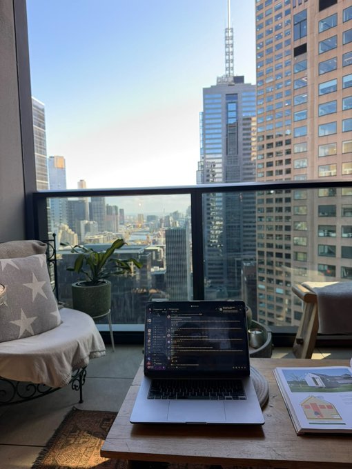 A laptop displays a Discord chat on a balcony table, with a skyscraper cityscape and potted plant in the background, promoting the Narrative Labs community server. The "discord.gg/narrativelabs" link invites viewers to join the online conversation being shown on screen.