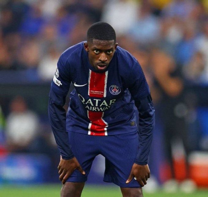 The image features a soccer player wearing a blue and red jersey, standing on a field and looking at the ground while holding his hands together. The background shows several people watching the game from various positions around the field. The caption of the image reads "GM CT => Wake up, think @wallchain => Tweet on @useTria => Engage with my mutual posts." This suggests that the soccer player is taking a moment to gather his thoughts and possibly communicate with others about the ongoing game or their experiences at the stadium.