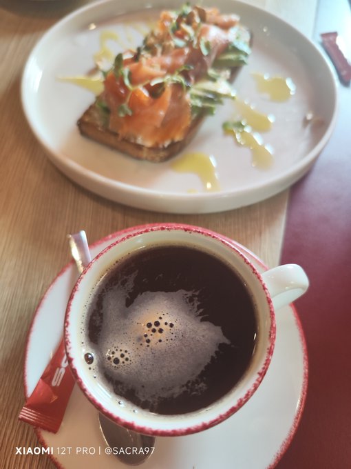 A photo taken with a Xiaomi 12T Pro (©SACRA97) showing a cup of black coffee on a saucer in the foreground with an open-faced salmon sandwich on a white plate in the background.