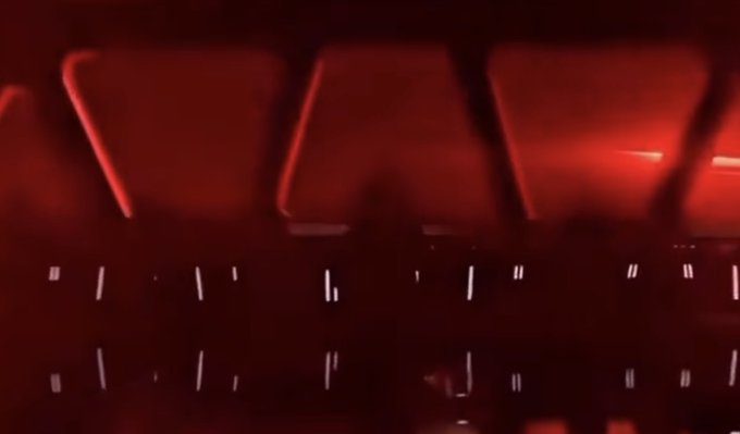 A blurry, close-up view of a red backlit gaming keyboard with glowing keycaps.