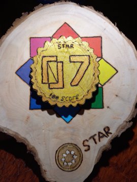 A custom gear-shaped wooden badge displays "07" and "STAR" carved and painted in gold at its center, with the word "STAR" burned into the wood below, commemorating Season 07 of the Soneium Score museum—the milestone when Startale missions first joined the ecosystem.