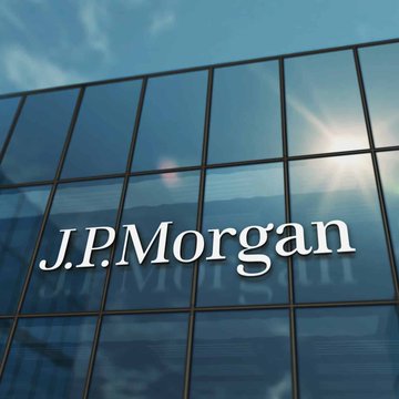 The image shows the JPMorgan logo on a glass office building, with sunlight reflecting off the facade. It accompanies the post highlighting JPMorgan as America’s biggest bank and emphasizing a bullish Bitcoin outlook.
