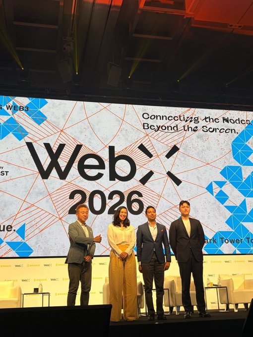 Four individuals stand on stage at the "WebX 2026" conference in Tokyo, with the event's tagline "Connecting the Nodes Beyond the Screen" displayed on a large screen behind them. The image appears unrelated to the accompanying text about XRP and cryptocurrency, as it simply shows speakers at a tech/web3 conference without any visible references to XRP or financial infrastructure.
