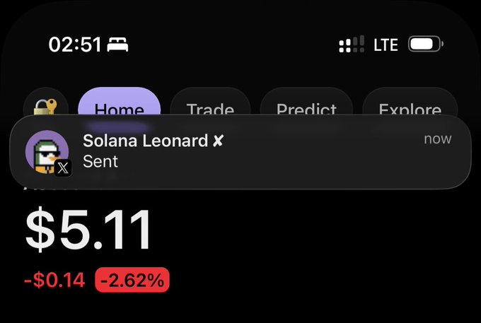 A smartphone screenshot showing a crypto app notification from 'Solana Leonard' showing a price of $5.11, down -$0.14 or -2.62%, with navigation tabs for Home, Trade, Predict, and Explore.
