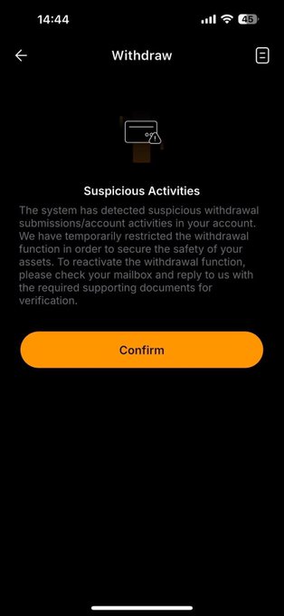 A mobile app screenshot showing a "Withdraw" page warning of "Suspicious Activities" and asking the user to verify via email, featuring a prominent orange "Confirm" button.