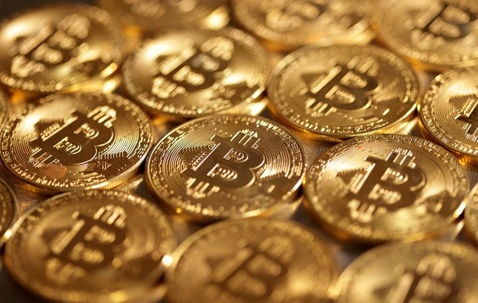 A pile of golden Bitcoin coins with the iconic "₿" symbol stacked together, illustrating the crypto market rally and $2.7B short squeeze highlighted for stocks like $MSTR, $COIN, $HOOD, $RIOT, $MARA, and $GLXY.
