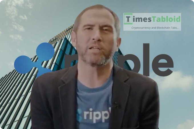 A man wearing a dark blazer and a blue 'ripple' t-shirt speaks in front of a Ripple logo background, with a 'TimesTabloid' watermark in the upper right corner.