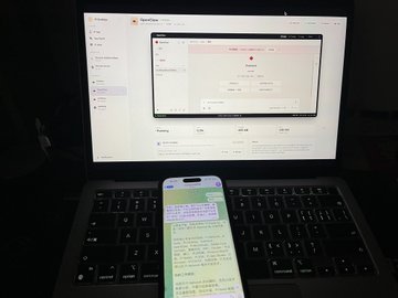 A laptop displaying a spreadsheet on its screen, with a smartphone in the foreground showing a messaging app with a conversation in Vietnamese.