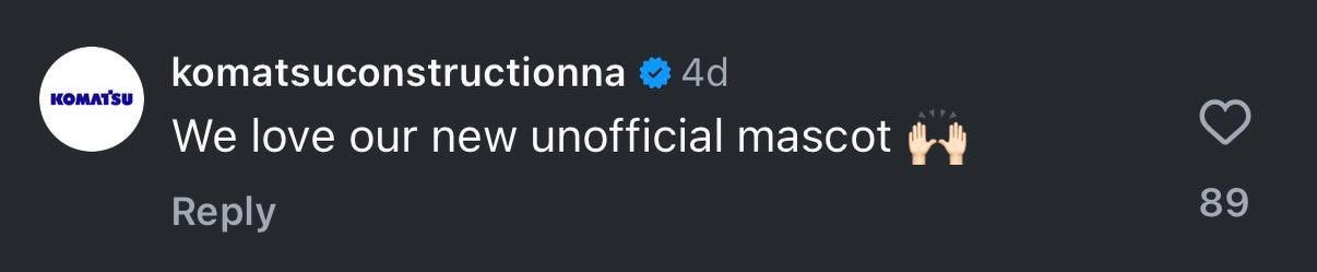 A social media comment from komatsuconstructiona saying 'We love our new unofficial mascot' with clapping emojis, receiving 89 likes.