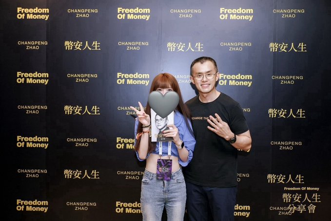 Two attendees pose in front of a "Freedom Of Money / 幣安人生 / CHANGPENG ZHAO" step-and-repeat backdrop, with one holding an event pass and the other (presumably Changpeng Zhao) flashing a peace sign. The photo ties to the post's gratitude toward "Teacher CZ," capturing a memorable moment from the BNB-related meetup.