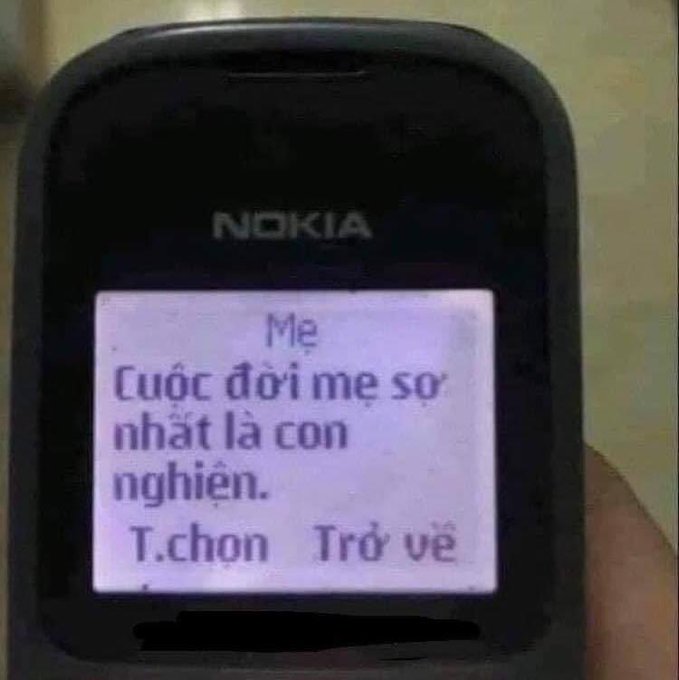 A close-up of a Nokia phone screen displaying a Vietnamese text message that reads 'Mẹ: Cuộc đời mẹ sợ nhất là con nghiện. T.chọn Trở về'.