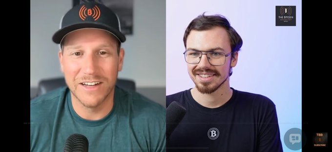 The image shows a split-screen video podcast with two men wearing branded "The Bitcoin" hats and shirts, appearing to record a Bitcoin-focused discussion. The post indicates the user just finished a 16-hour workday and is enjoying listening to the podcast.
