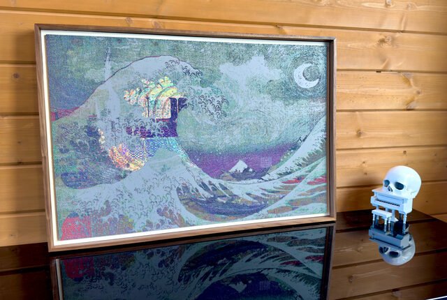 A framed pointillist-style reinterpretation of Van Gogh's "The Starry Night" featuring swirling waves and a crescent moon, displayed on a reflective surface beside a small skull figurine against a wooden plank wall. This piece reflects ACK's signature style referenced in the post, showcasing the artist's distinctive reinterpretation of classical works that made them a celebrated figure in crypto-native art.