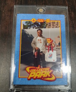 A collectible trading card in a protective case features a person standing outdoors, with 'Electron Park' logo and '52' visible on the card.