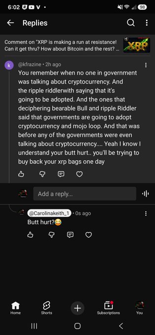 Screenshot of YouTube replies discussing cryptocurrency, with user @kfrazine mocking XRP critics and @Carolinakeith_1 replying 'Butt hurt?'