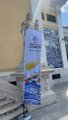 A vertical banner outside a building displays "NaoX" branding with blockchain-related graphics, illustrating the post's claim that NaoX is an EVM-compatible, post-quantum blockchain where developers can build the same types of applications as on Ethereum, including DeFi, stablecoins, and gaming.