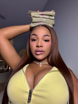 A woman in a yellow zip-up top holds stacks of cash bound with pink bands above her head, visually echoing the caption "$ excites me" as she proudly displays the money.