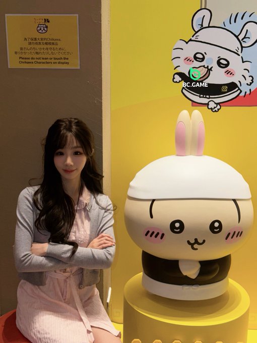 The image features a woman sitting next to a large bunny statue with a white hat. The woman has her arms crossed over her chest as she poses beside the statue. In the background, there are signs that read "BC Game" and "I never thought so many people would like me!! I thought everyone was secretly cursing me behind my back! That'S just who I am!". This suggests that the woman is promoting a game or event related to the bunny statue, possibly drawing attention to it.

The image also contains text about trading coins on-chain and hyping things up for everyone on-chain. The combination of these elements creates an interesting juxtaposition between the woman's pose with the bunny statue and the more serious theme of coin trading.
