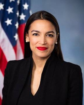 A formal portrait of a woman with long dark hair, wearing a black blazer and red lipstick, posed in front of an American flag. The image appears to be an official congressional-style photo that aligns with the post's reference to AOC (Alexandria Ocasio-Cortez), a prominent U.S. politician, used here in connection with a thesis predicting her potential rise in political prominence.