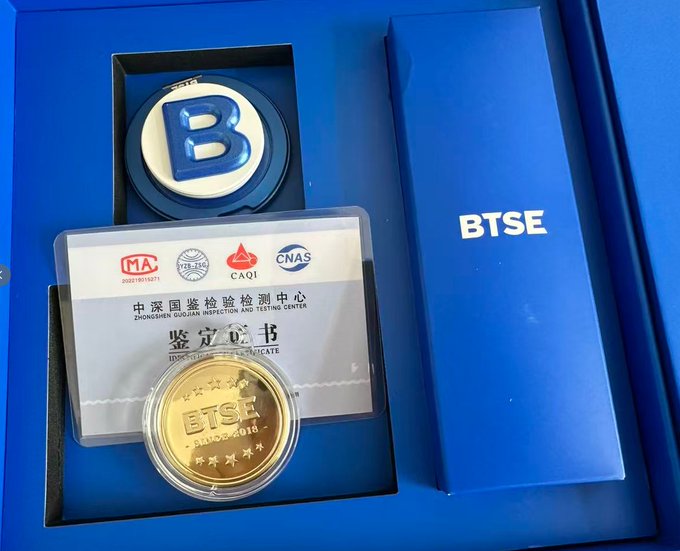 A BTSE-branded gift box containing a blue "B" emblem, a gold commemorative coin labeled "BTSE PURE GOLD," and a certificate of authentication from the Zhongguan Duibao Inspection and Testing Center, presented as a Mid-Autumn Festival gift from BTSE.