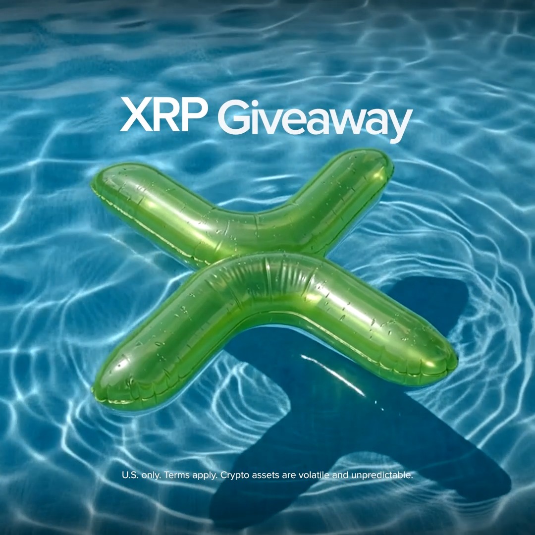 A green inflatable "X" floats in a swimming pool beneath the text "XRP Giveaway," visually tying into Uphold's 4th of July holiday promotion where 5 winners will receive $100 in XRP each. The image's pool float serves as a summer-themed, playful backdrop for the contest entry announcement.
