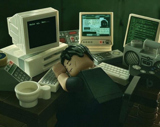The image features a man sleeping at a desk with various computer equipment, including multiple monitors, keyboards, mice, and other devices such as a cup of coffee and a remote control. The caption reads "Never want to miss any opportunity on @base All I want is base". This suggests that the man might be working in an office environment or using technology for work purposes while taking breaks to rest his eyes from staring at screens all day.