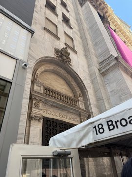 The image shows a tall building with an archway entrance that reads "18 BROOKS STOCK EXCHANGE". The building has a stone facade, which adds architectural interest to the scene. In front of the building, there are two people walking by, one person closer to the left side and another person further back on the right side.

The post also mentions tokenization, securitizing assets, and Ondo Finance as interesting topics happening in the world of finance. These terms can be seen throughout the image, such as "18 BROOKS STOCK EXCHANGE", "Securitize", and "Ondo Finance". The presence of these words suggests that the building's entrance might be related to a financial institution or an event focused on finance-related topics.

The image captures a moment in time where people are walking by, possibly discussing or exploring the building with interest.